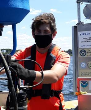Nate Dugener on pontoon boat holding subsurface sensor buoy